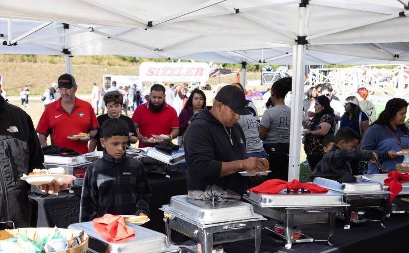Guests being served at a large-scale catering buffet line by RH Events & Catering