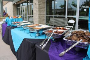 Large-scale buffet lines with prepared dishes for an outdoor event by RH Events & Catering