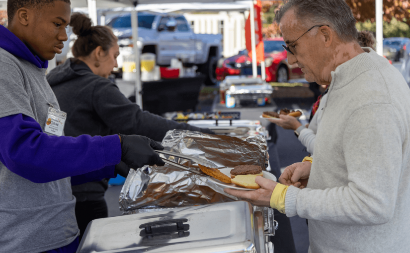 RH Events & Catering assisting a participant in the buffet during a large-scale company picnin