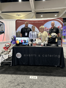 a group of people standing at a table with stuffed animals