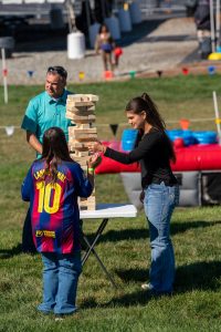company employee with family playing Giant Jenga during company picnic event
